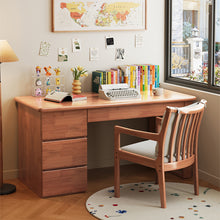 Load image into Gallery viewer, Modern solid wood study desk with drawers paired with a matching wooden armchair by a window