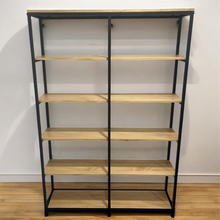 Load image into Gallery viewer, Bookshelf with wooden shelves and black metal frame against a white wall.